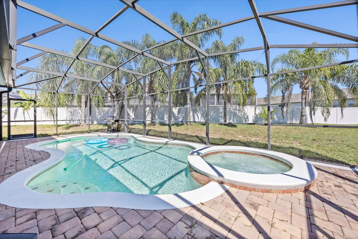 Dive into vacation mode! Enjoy your private screened-in pool and bubbling spa surrounded by Florida sunshine and palm trees.