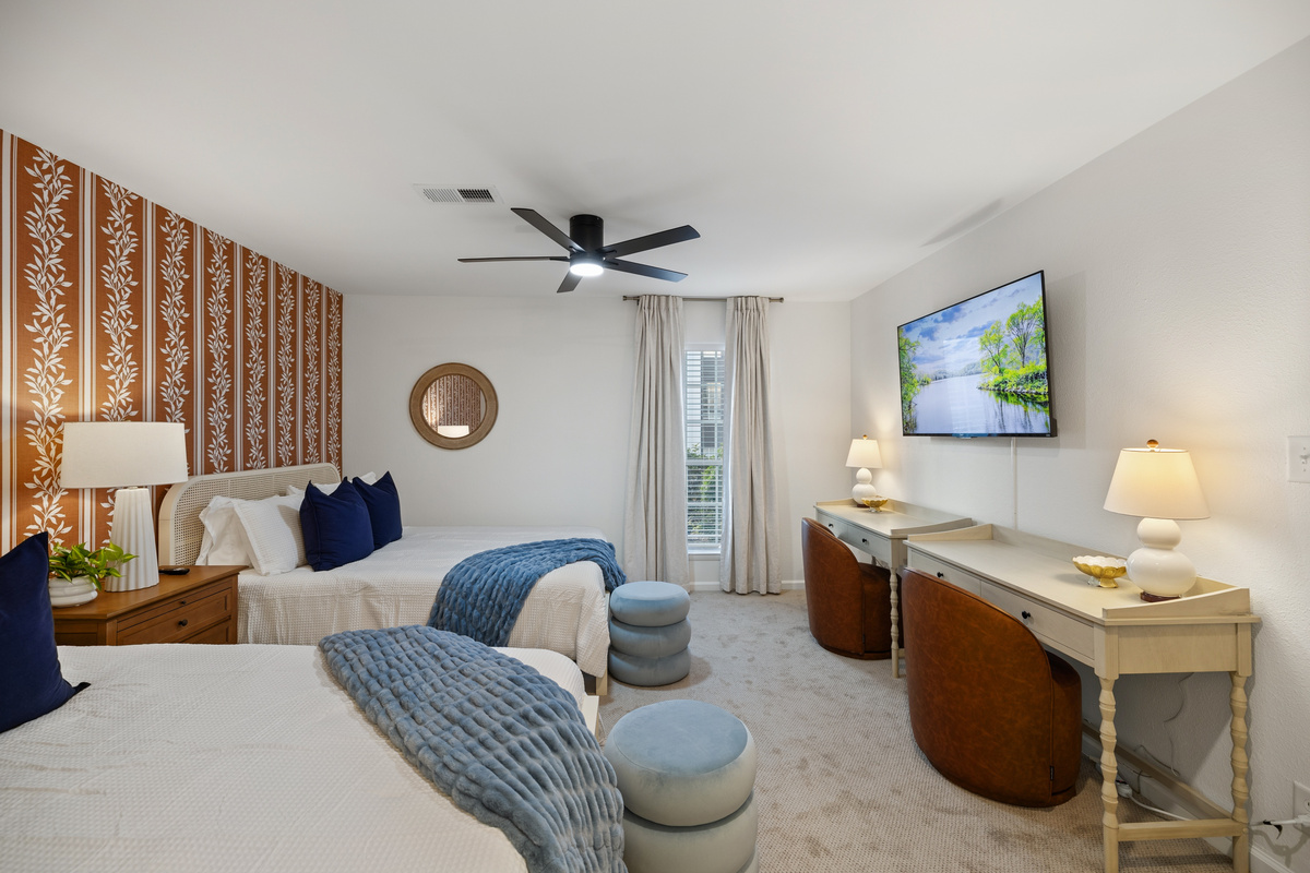 Beds on one side, two desks and a Smart TV on the other. Parents' weekend and a work week both fit.