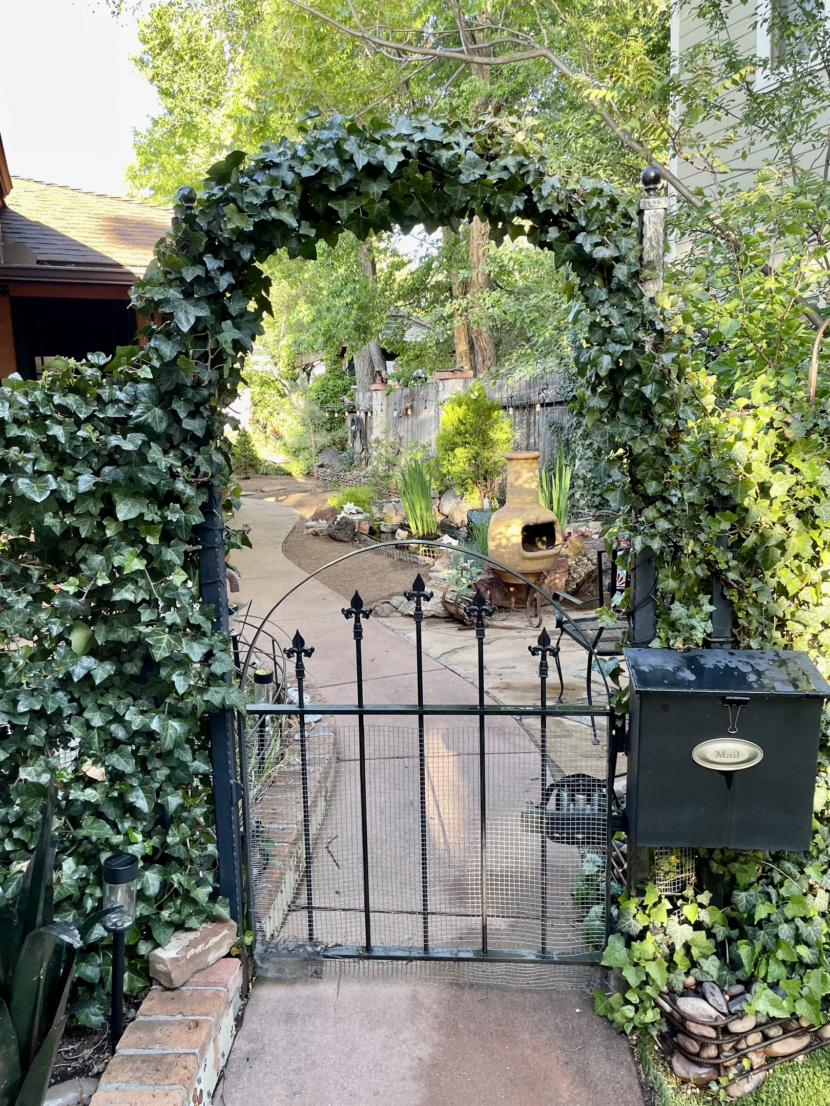 Unwind in this enchanting garden, where softly lit ivy arches create a tranquil haven for evening relaxation.