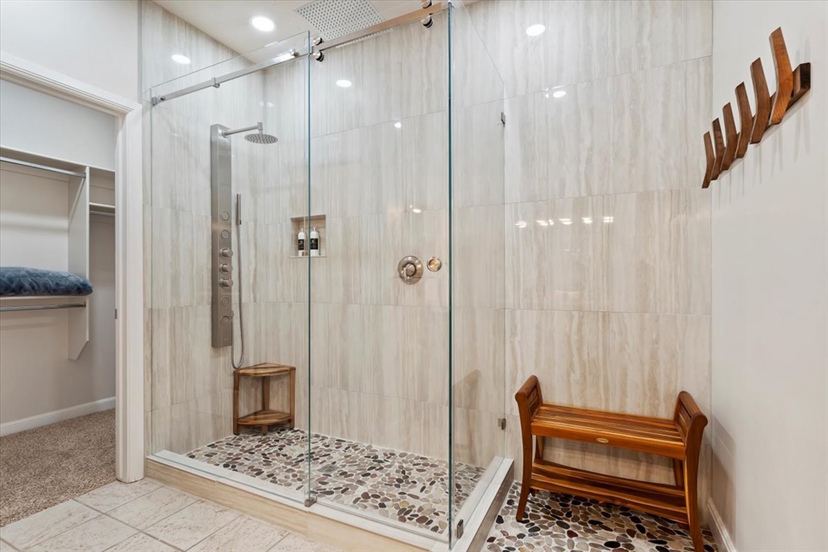 Step into a spacious walk-in shower with built-in bench seating—perfect for relaxing and refreshing after a day in the mountains.