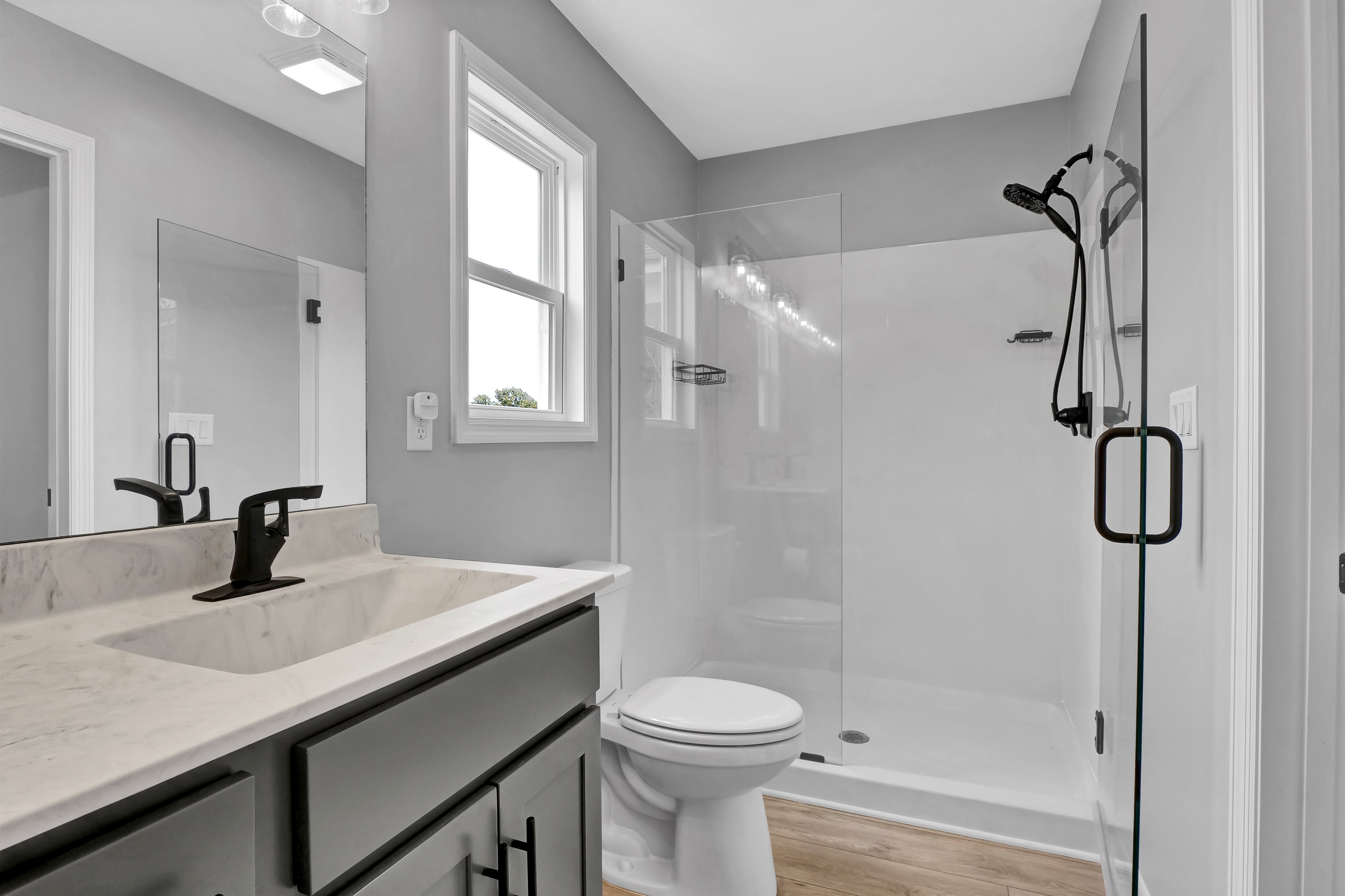Modern en-suite bathroom with double sinks and glass shower—perfect for unwinding after a day at the beach
