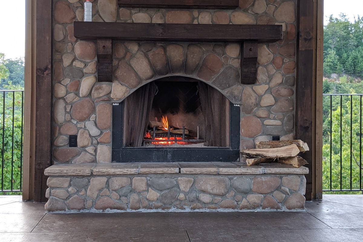 - Stone fireplace glowing warmly against a backdrop of forest views   - Gather around for cozy evenings filled with mountain air and crackling fire   - The perfect outdoor space to unwind after a day of Smoky Mountain fun