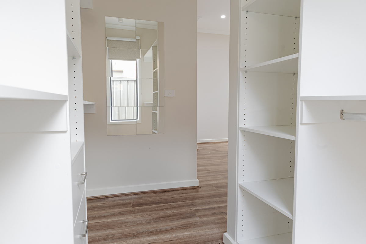 Open shelving, hanging space and built-in drawers make this wardrobe area practical for unpacking and keeping bags out of the bedroom.