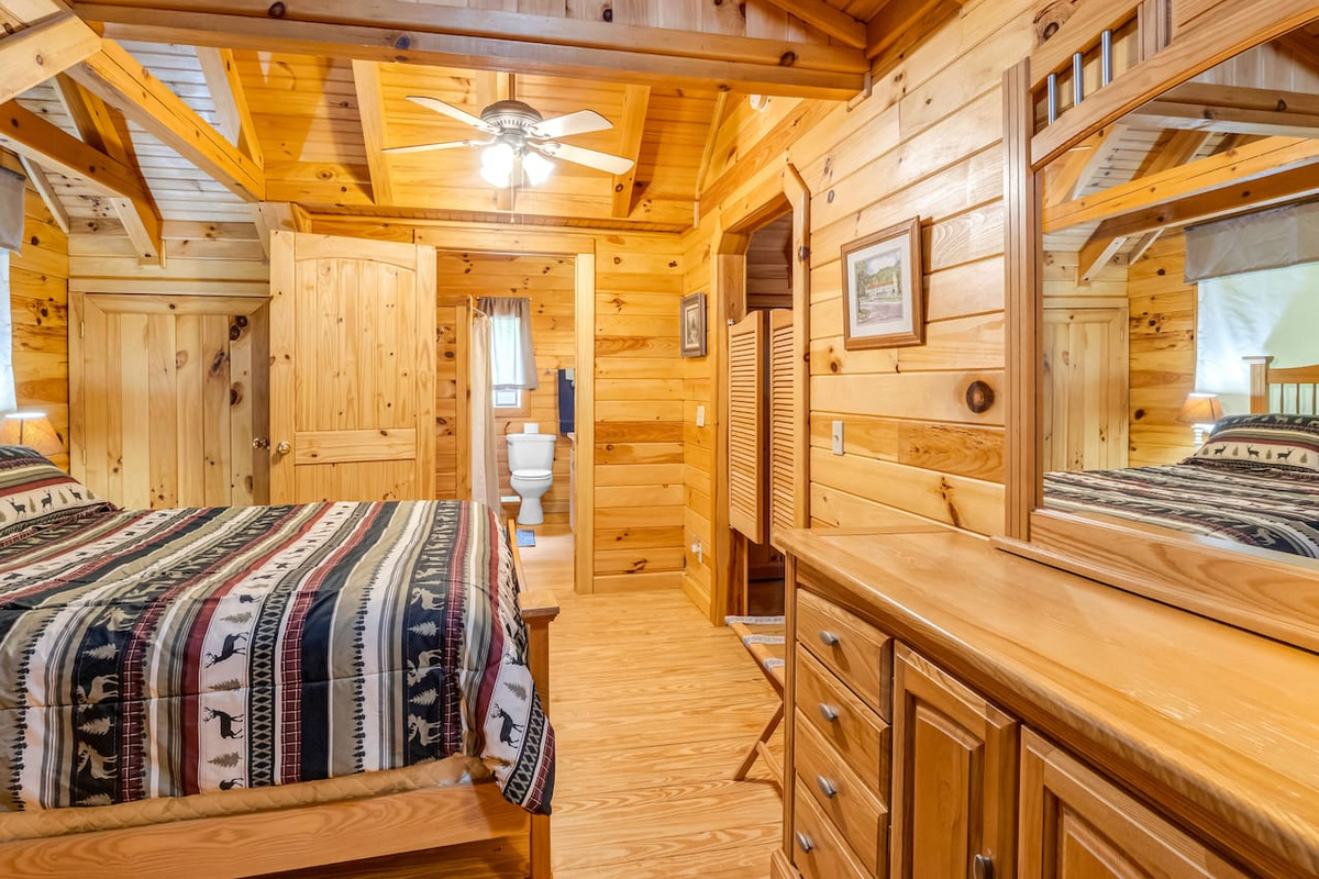 Third-level bedroom featuring a comfortable double bed, private bathroom, saloon doors, and plenty of storage space