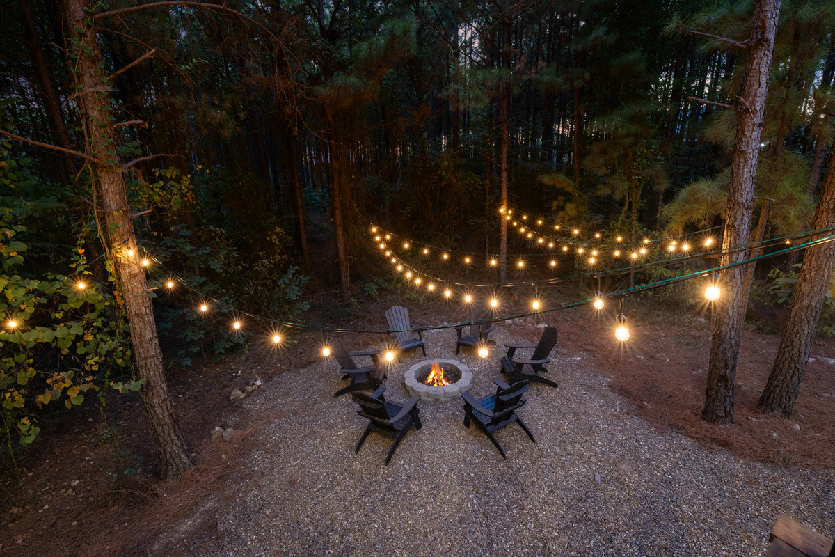 This is the kind of privacy people come to Broken Bow for. A fire glowing beneath the string lights, towering pines in every direction, and forest stretching for miles beyond, creating a true sense of seclusion.