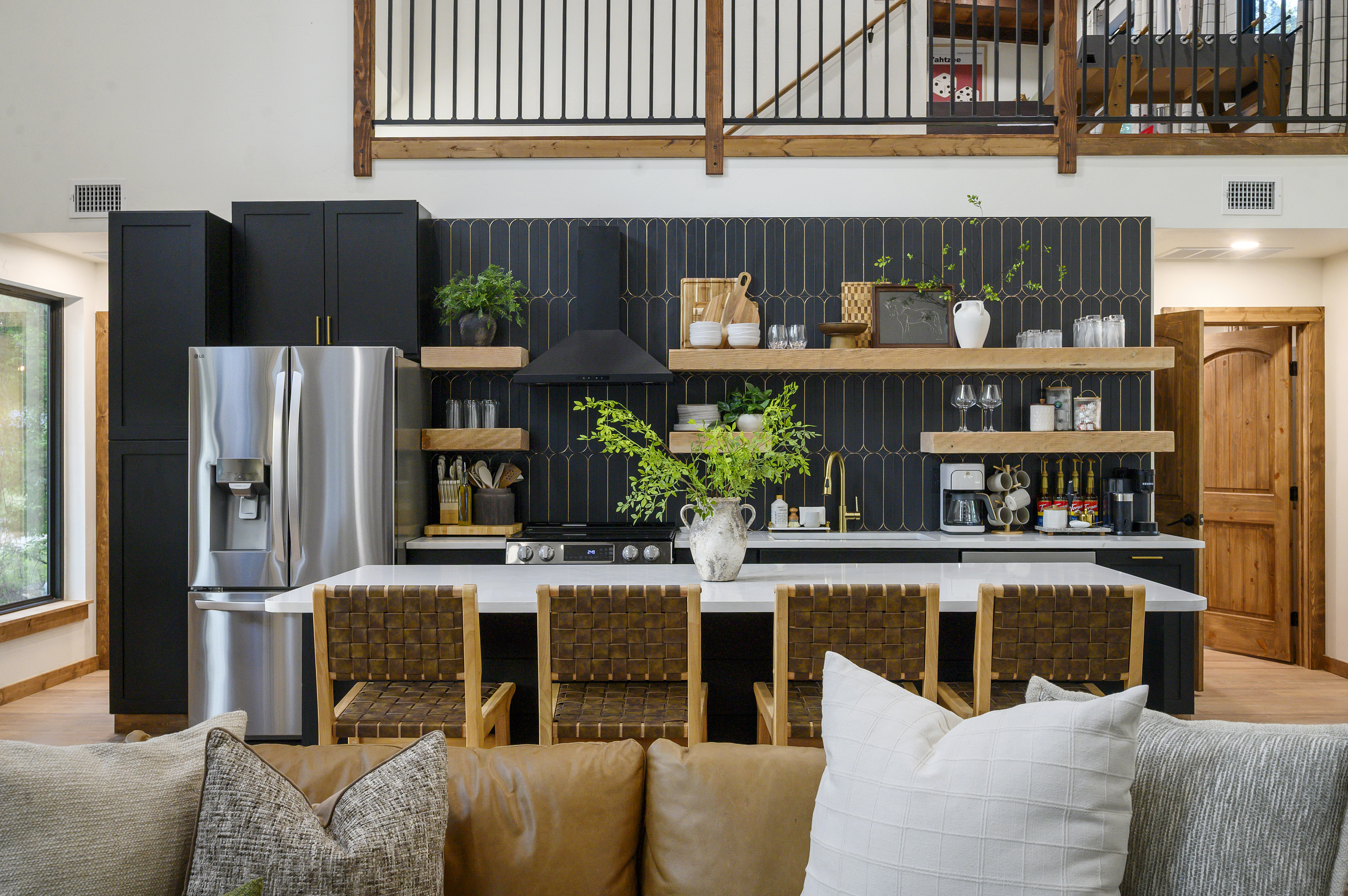 A kitchen that feels as good as it functions. Striking black and gold finishes, warm wood shelving & an oversized island create a beautiful space for everything from pancake mornings to dinner and drinks together.
