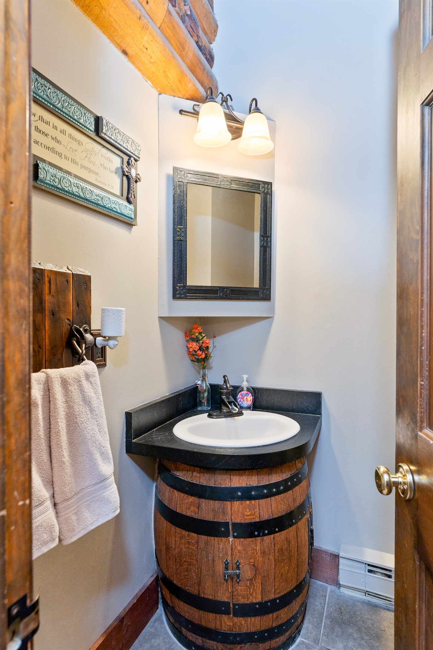 Unique main floor half-bath with a custom whiskey barrel vanity and modern fixtures, blending rustic charm with practical style.