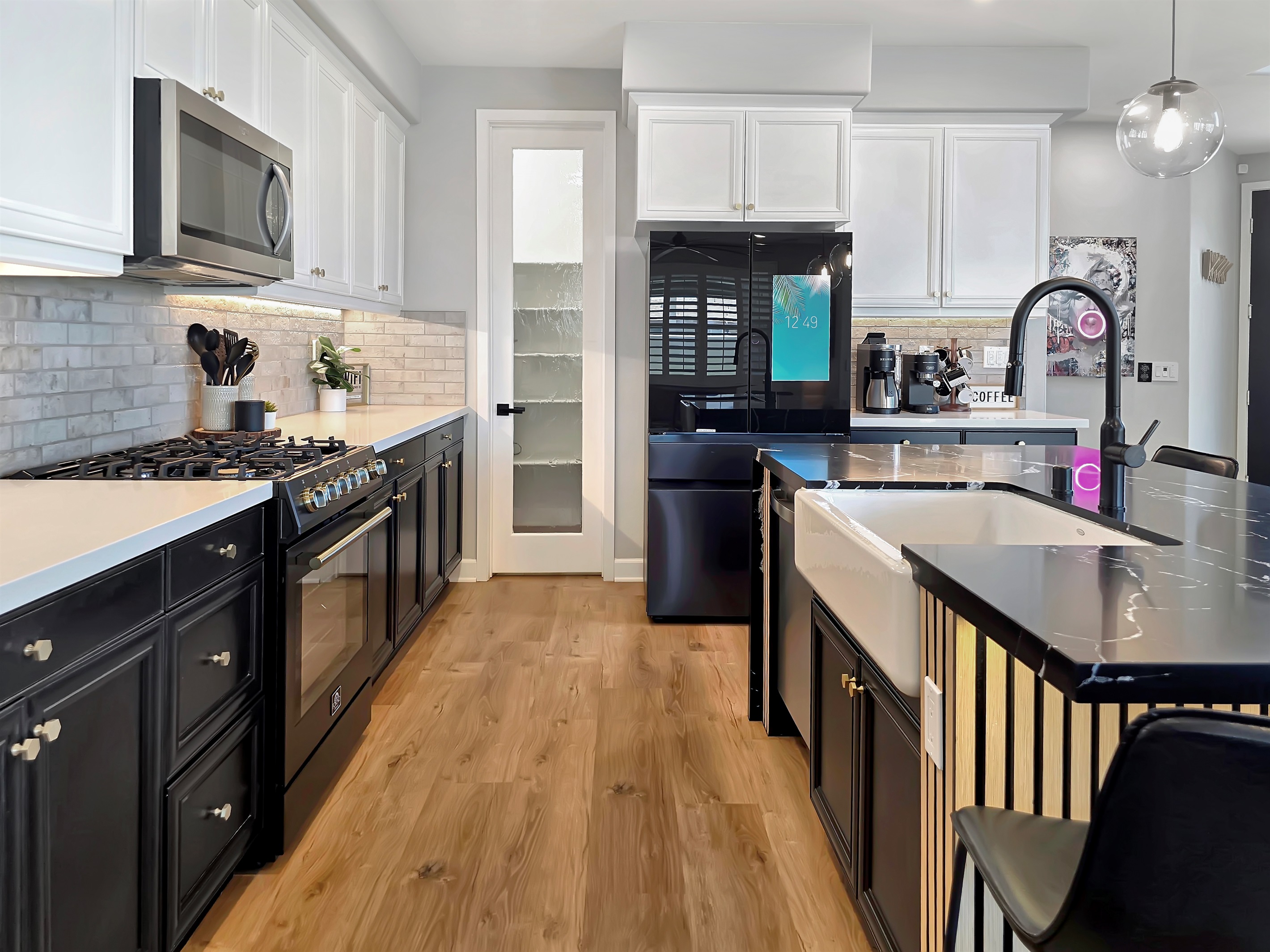 The kitchen features tuxedo style cabinets with a white farm sink.
