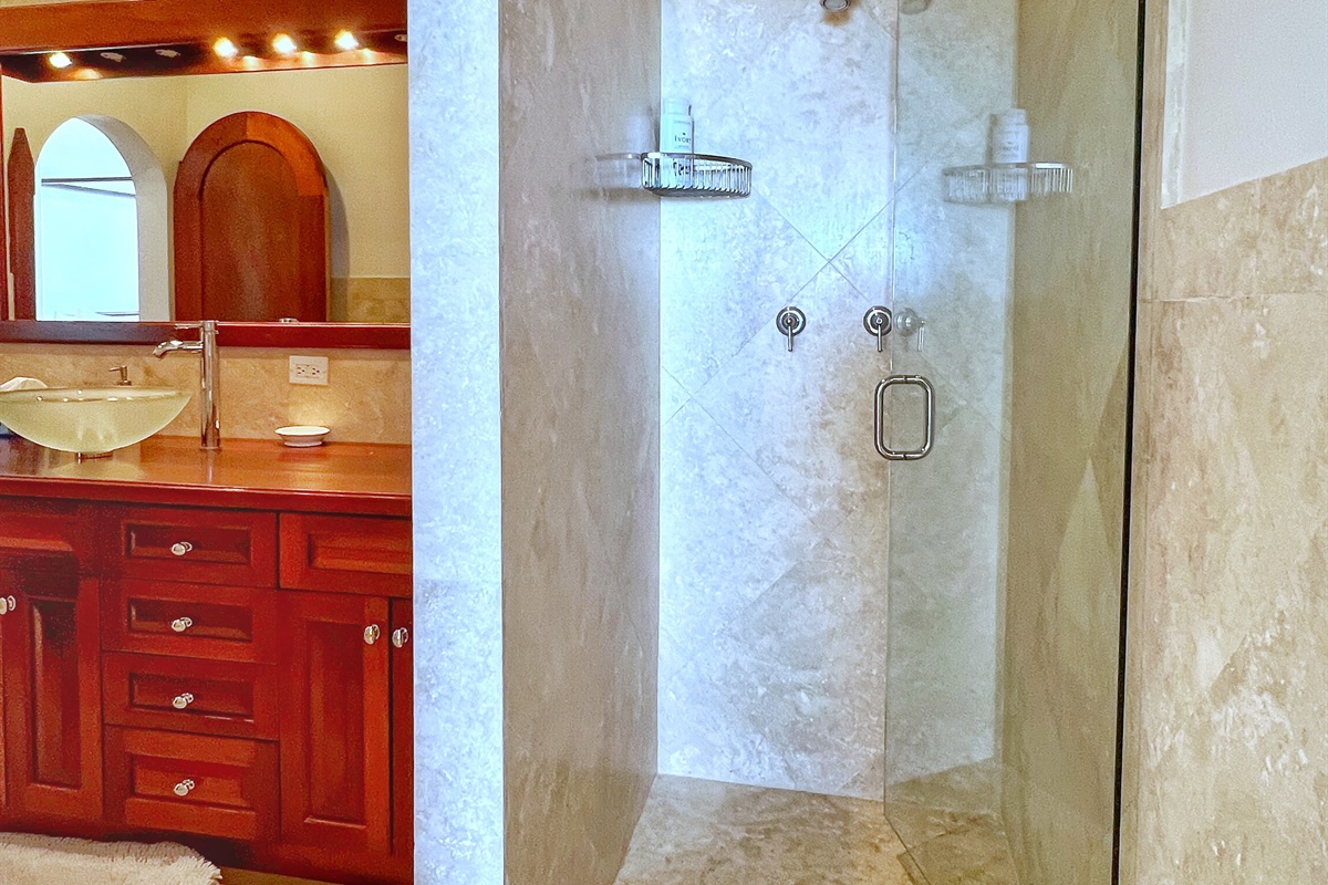 Has a travertine lined, walk-in shower.