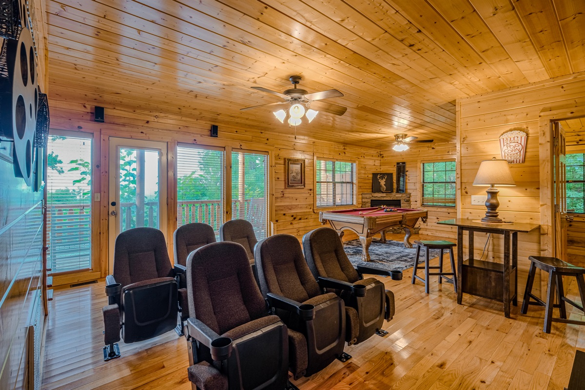 Theater and game room on lower level with access to lower level deck which has hot tub and seating to relax and enjoy the outdoors