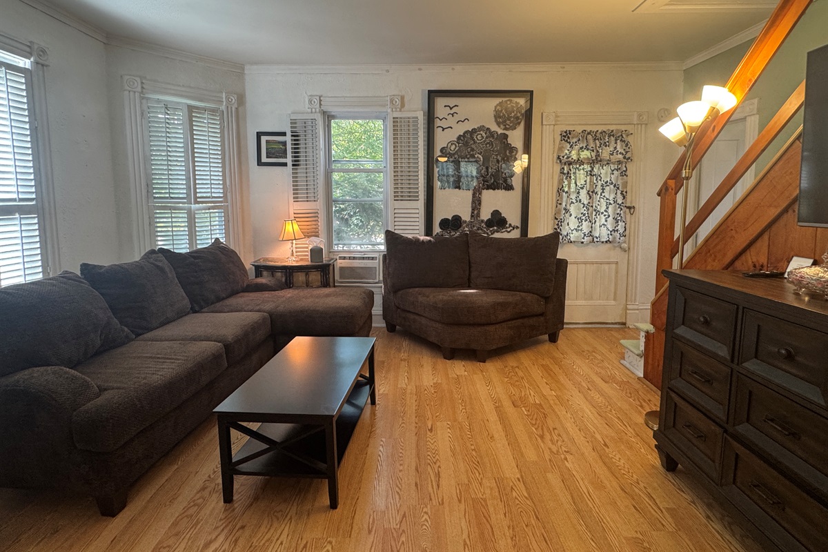 Main living room with comfy couches and large TV
