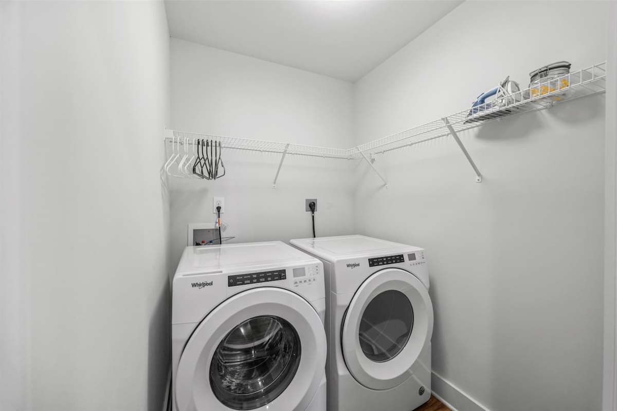 Convenient washer and dryer with shelving for storage, making stays simple and stress-free.