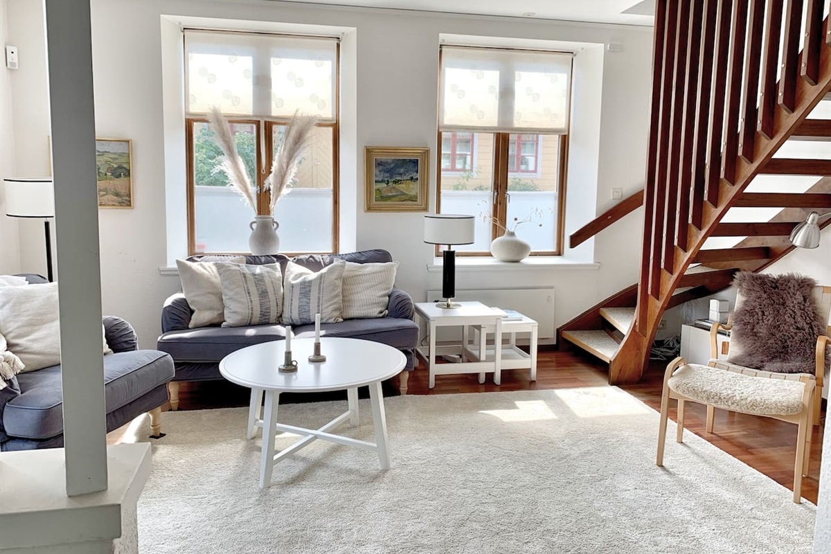 Vardagsrum med soffgrupp, tv och altandörr ut till trädgården. 