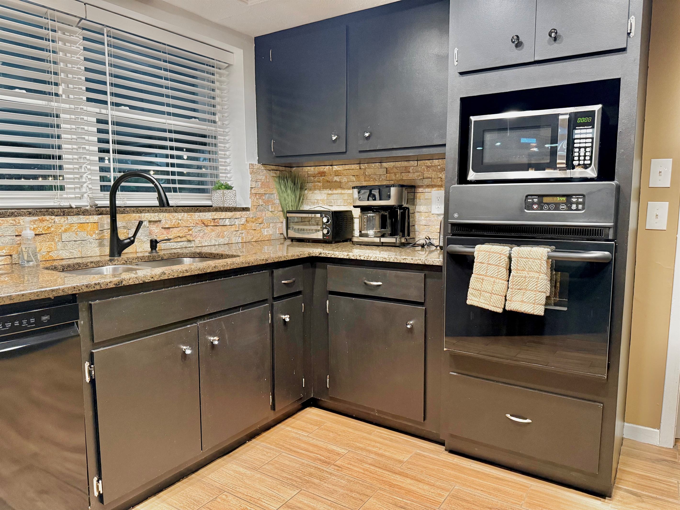 From a built-in oven to a microwave, toaster, coffee maker, and blender, this kitchen is stocked with all the essentials for cooking, baking, and snacking in comfort.