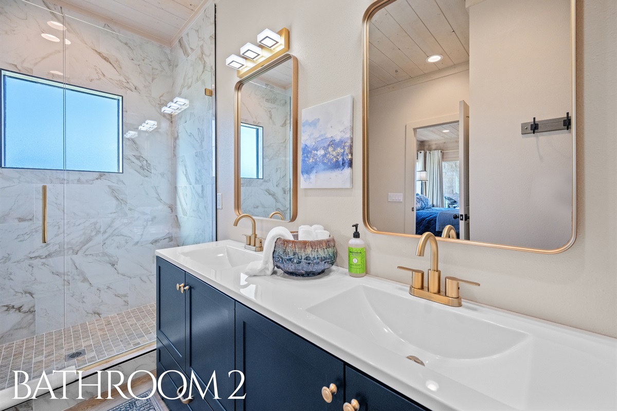 Bathroom 2 with double vanity, marble accents, and stylish lighting.