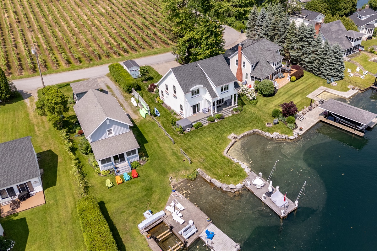 Stunning aerial view of a serene Finger Lakes waterfront retreat, complete with private dock, lush greenery, and charming lakefront homes—perfect for peaceful getaways and water adventures