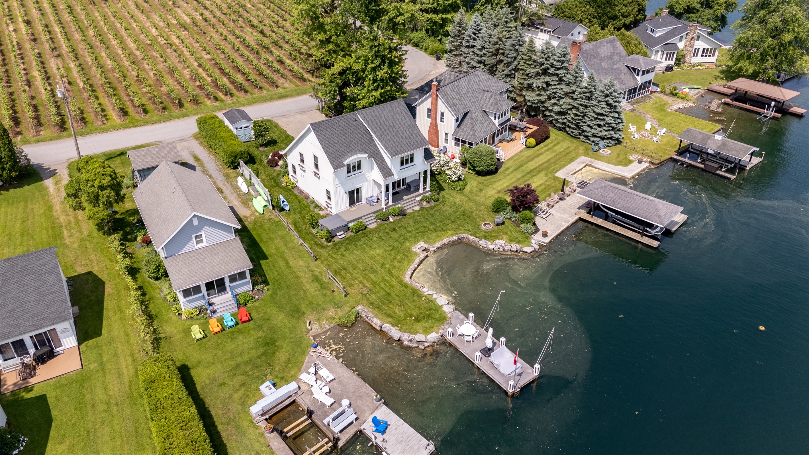 Stunning aerial view of a serene Finger Lakes waterfront retreat, complete with private dock, lush greenery, and charming lakefront homes—perfect for peaceful getaways and water adventures