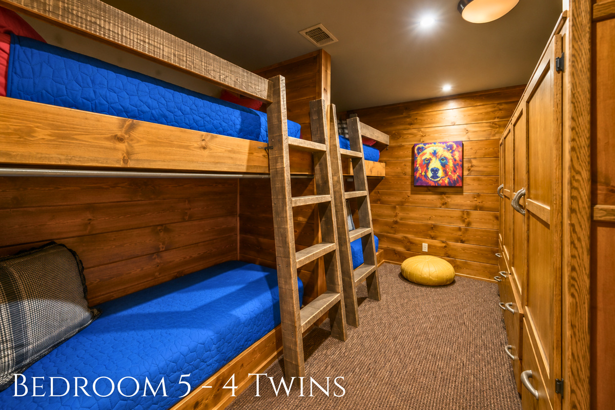 Bright blue bedding adds a playful pop of color to the twin bunk room, with multiple beds giving younger guests plenty of space to settle in together.