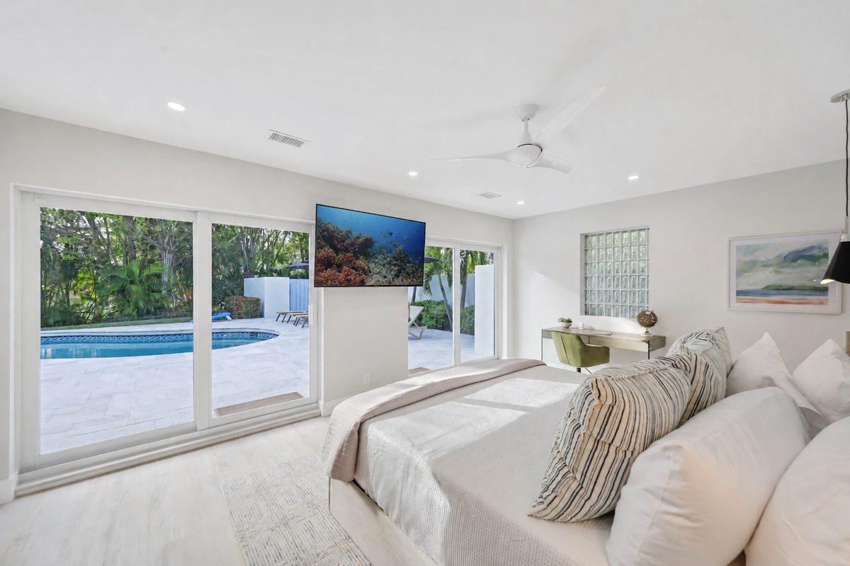 Wake up to pool views from this king bedroom, with a wall-mounted TV and workspace for a longer, more comfortable Delray Beach stay.