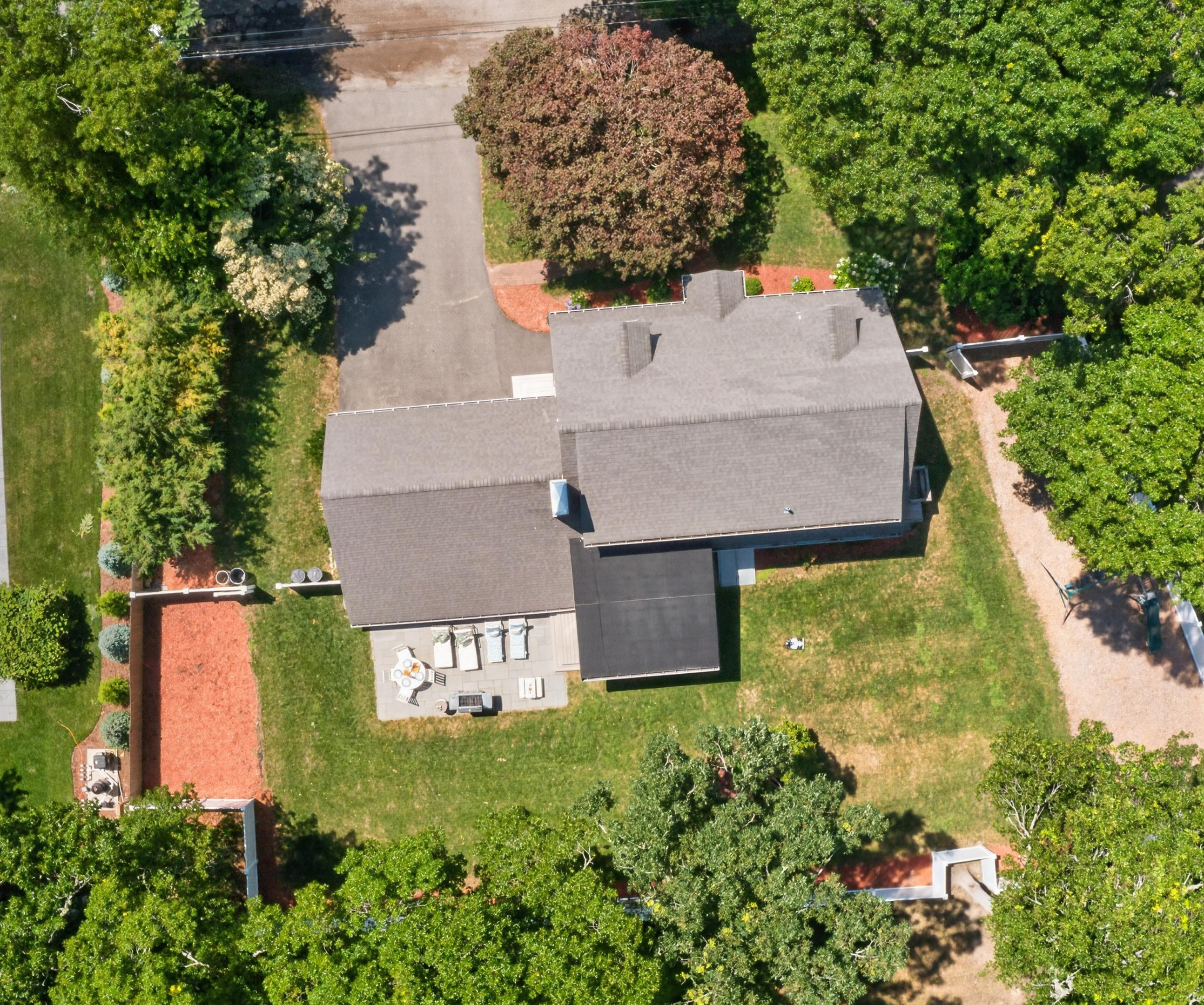 Bird's-eye view of the private backyard with patio, grill, and fully fenced yard.