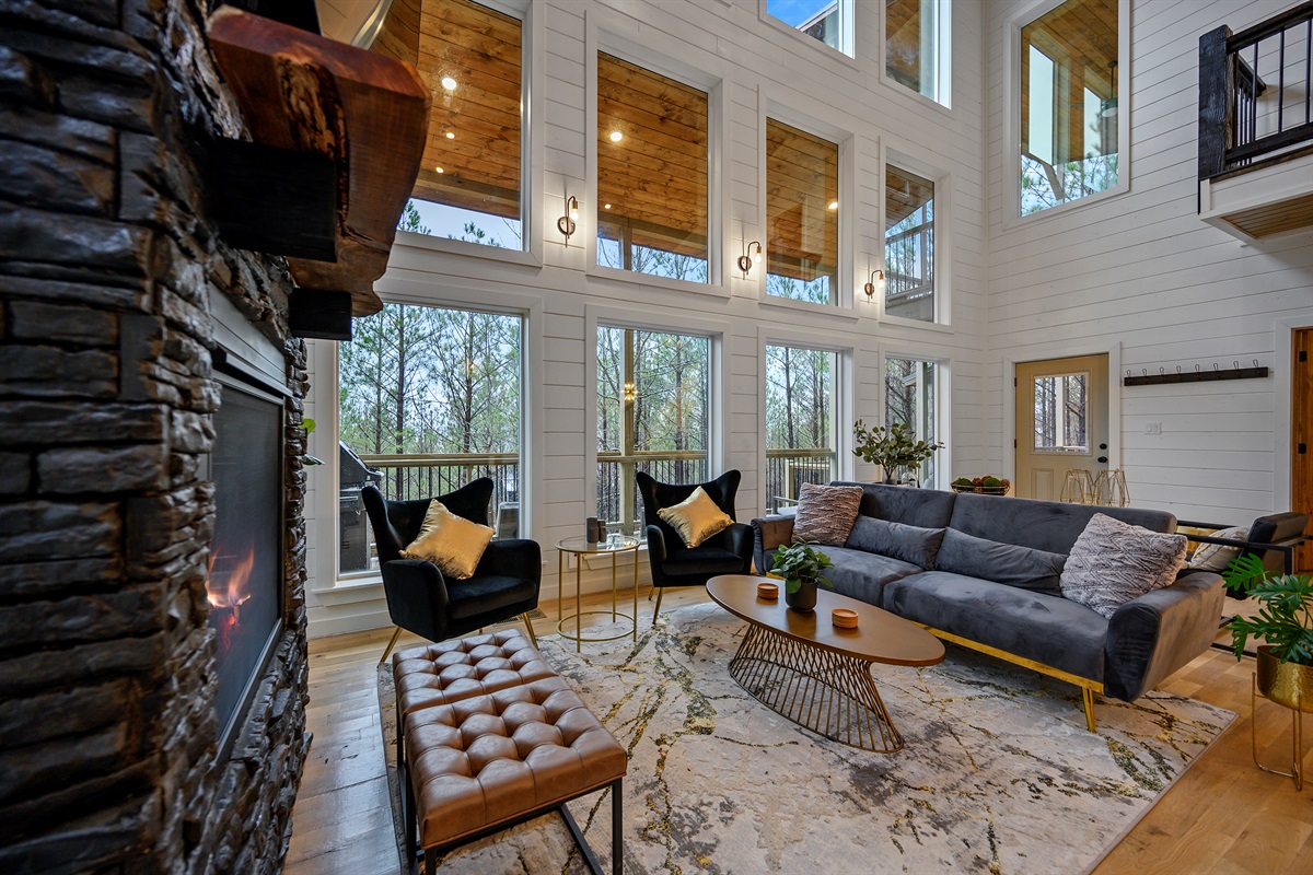 A warm and spacious living area designed for gathering and unwinding — featuring plush seating, cozy accent chairs, a stunning fireplace, and a large TV perfect for movie nights after a day of adventure. ✨