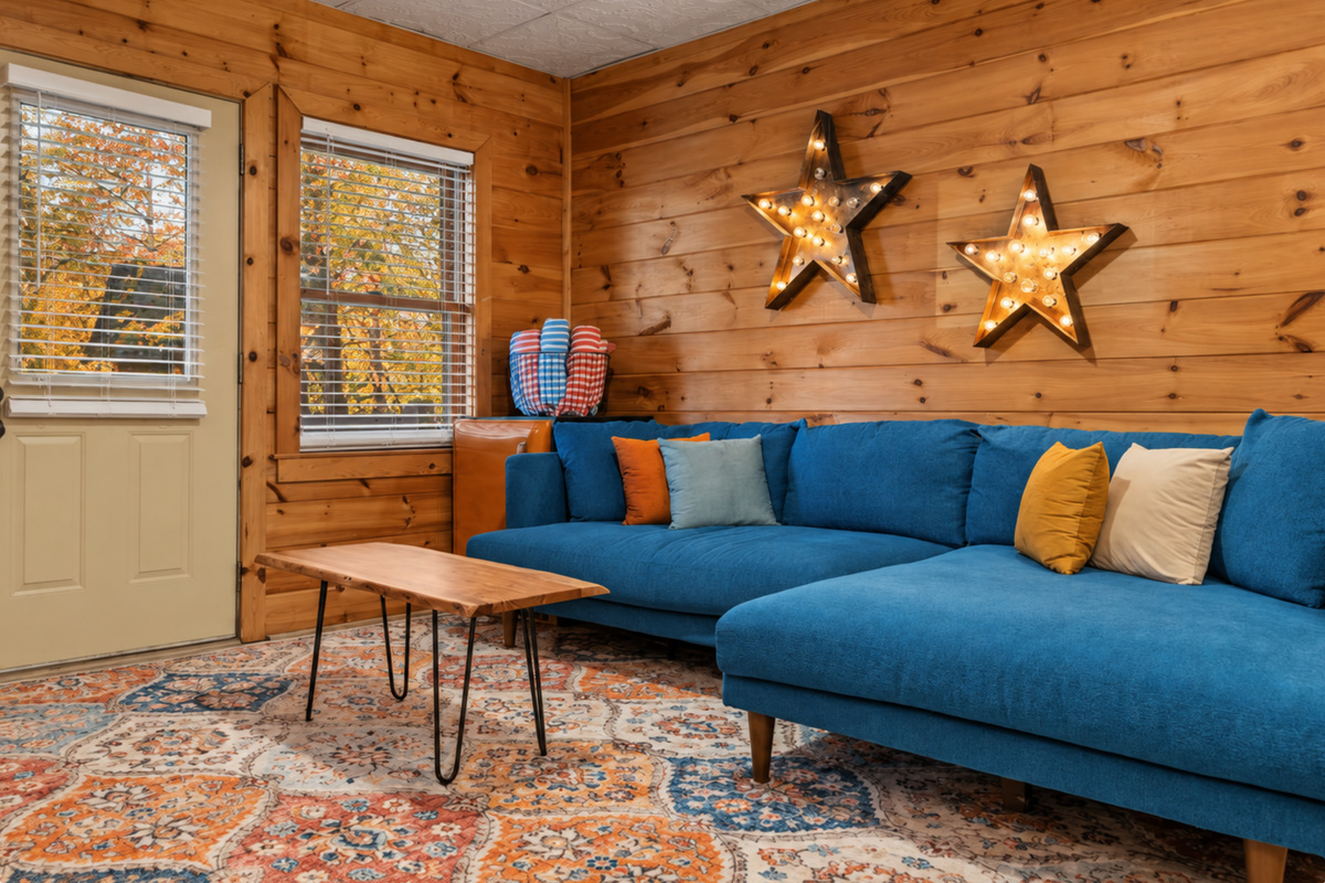 The game room calls, with a turquoise couch, mini fridge, and space to unwind.