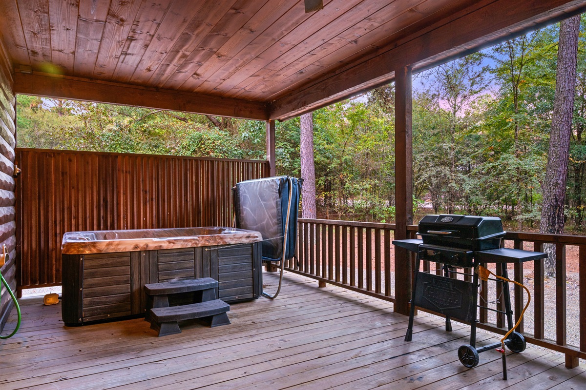 Covered deck with grill and seating for outdoor dining.