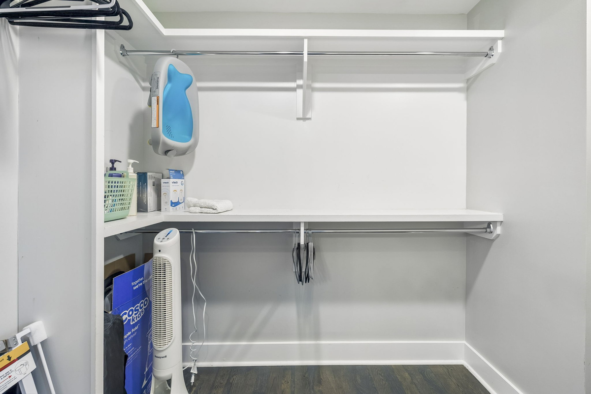 Generous shelving and dual hanging rods provide extra space for all your belongings - Clean white finishes and wood flooring create a crisp, organized storage area - Ideal for longer stays, offering plenty of room for suitcases, shoes, and wardrobe