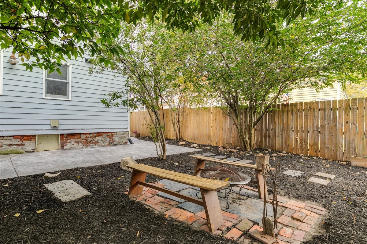 Backyard Oasis: Gather around the fire pit under lush trees and enjoy evening conversations!