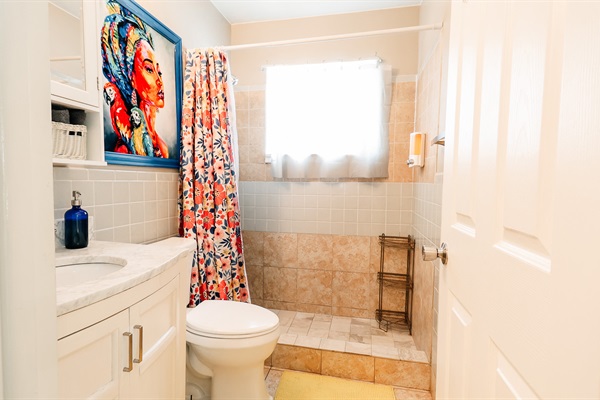 Artistic Sanctuary: Toilet and Sink in a Stylish Bathroom, Elevated by a Striking Painting of a Woman with a Blue Frame, and a Functional Cabinet with Mirror 🚽🖼️🚿