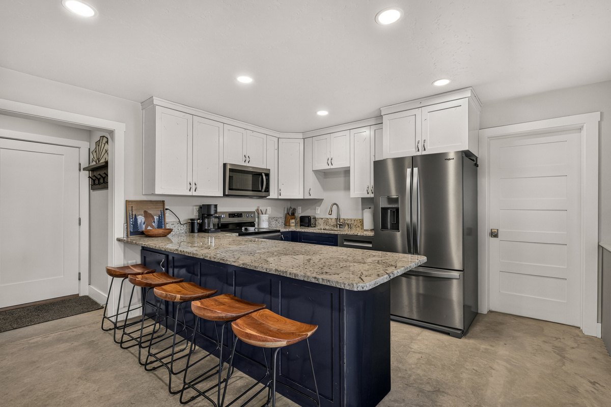 Fully equipped kitchen with extra barstool seating.
