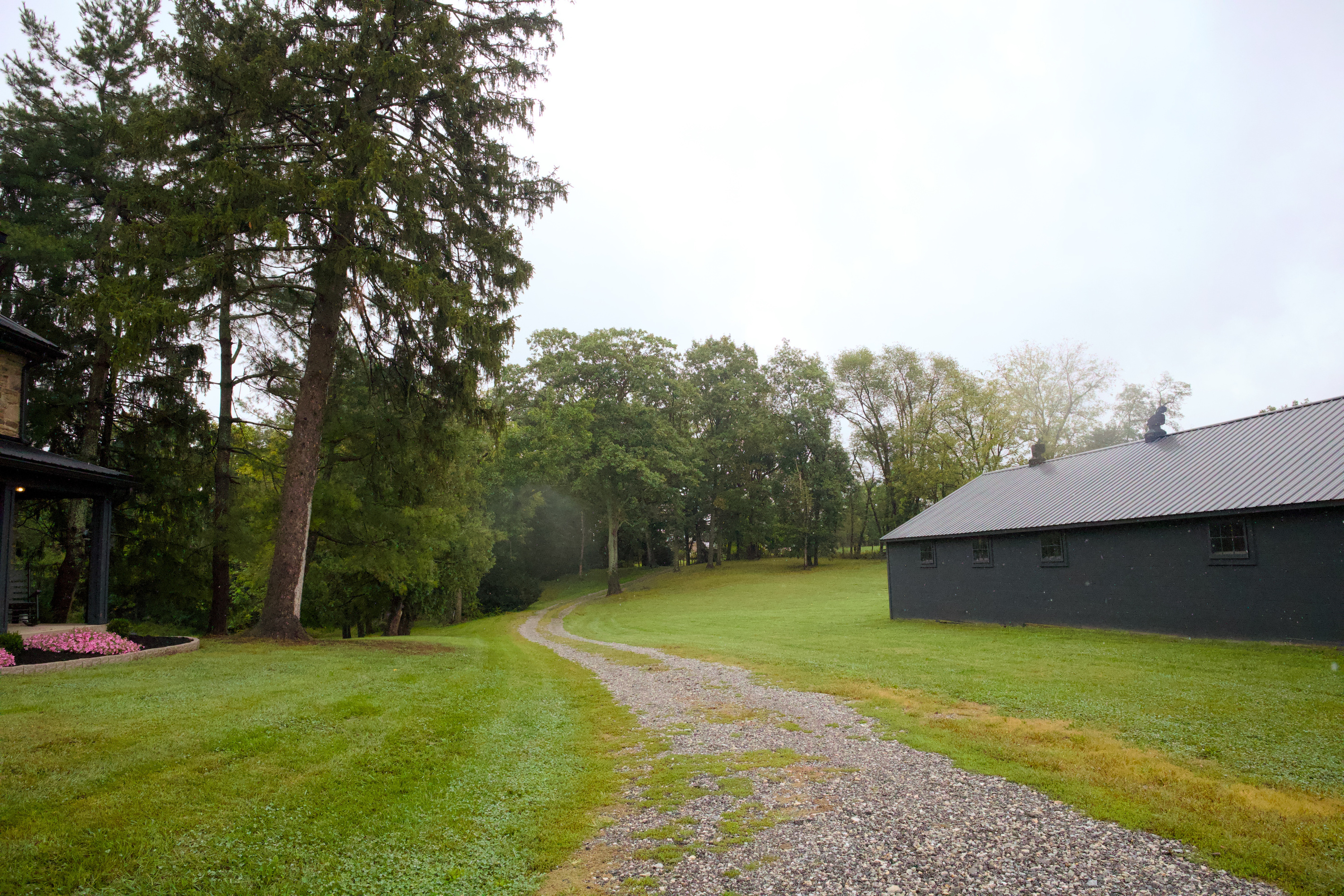 Tucked well off the road, the driveway winds through the woods before opening onto the farm