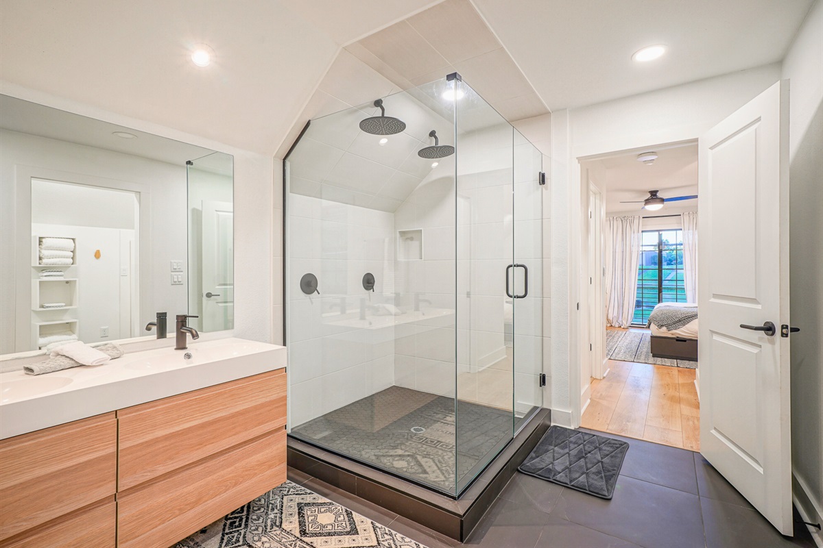 This ensuite bathroom brings a hotel-style vibe with clean lines, high-end finishes, and a massive walk-in shower.