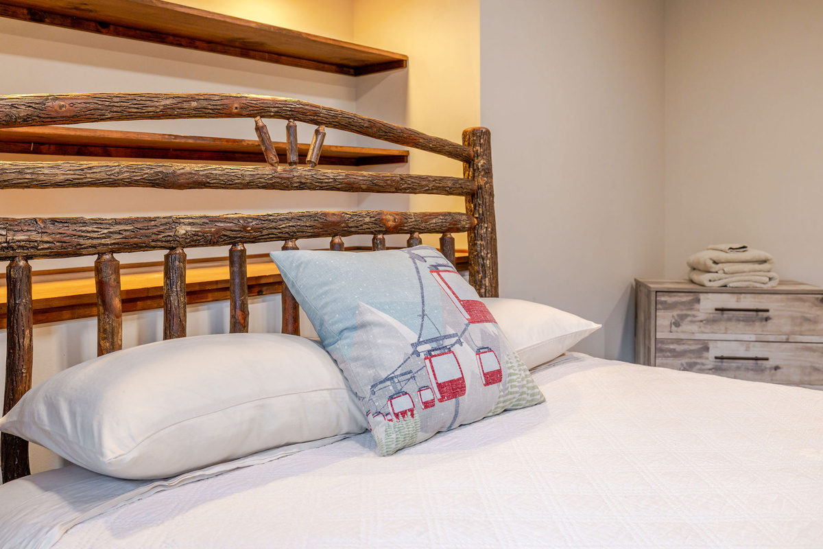 Rustic craftsmanship and cozy comfort come together in the handcrafted log bed, creating a memorable Adirondack getaway experience.