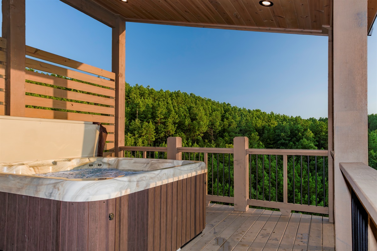 A covered deck, warm bubbling water, and endless green views—this is how mountain relaxation should feel.