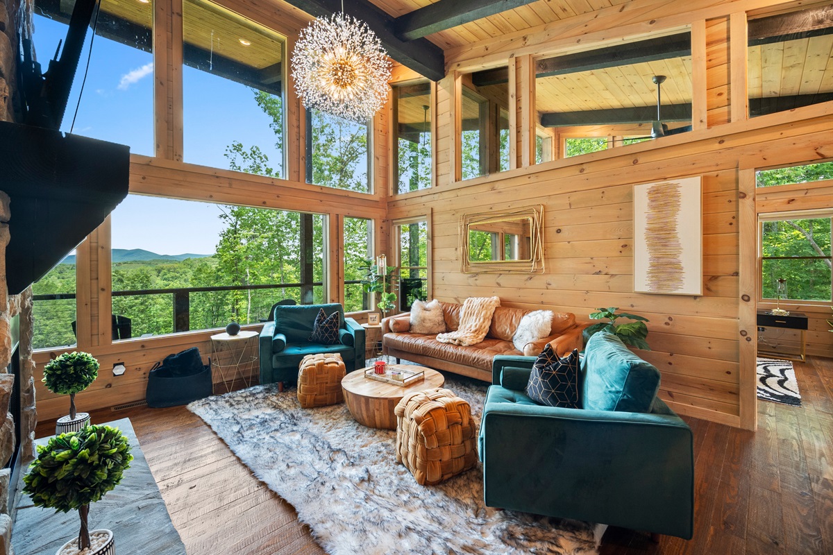 The bright and airy living room is the centerpiece of comfort, with floor-to-ceiling windows that bring the stunning natural surroundings indoors.