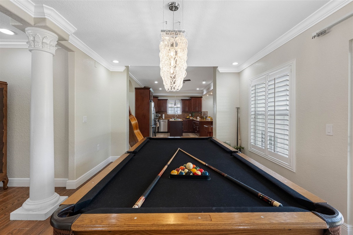Enjoy a game of billiards while taking in the scenic waterfront backdrop. This game room boasts warm wood flooring, modern lighting, and easy access to the outdoor patio.