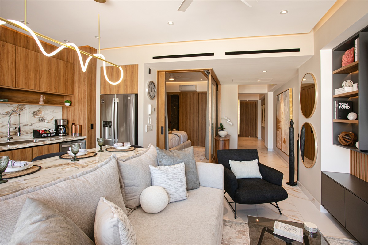 The modern living room includes a plush sleeper sofa that sleeps two comfortably, with their own private bathroom located just steps away along the hallway.