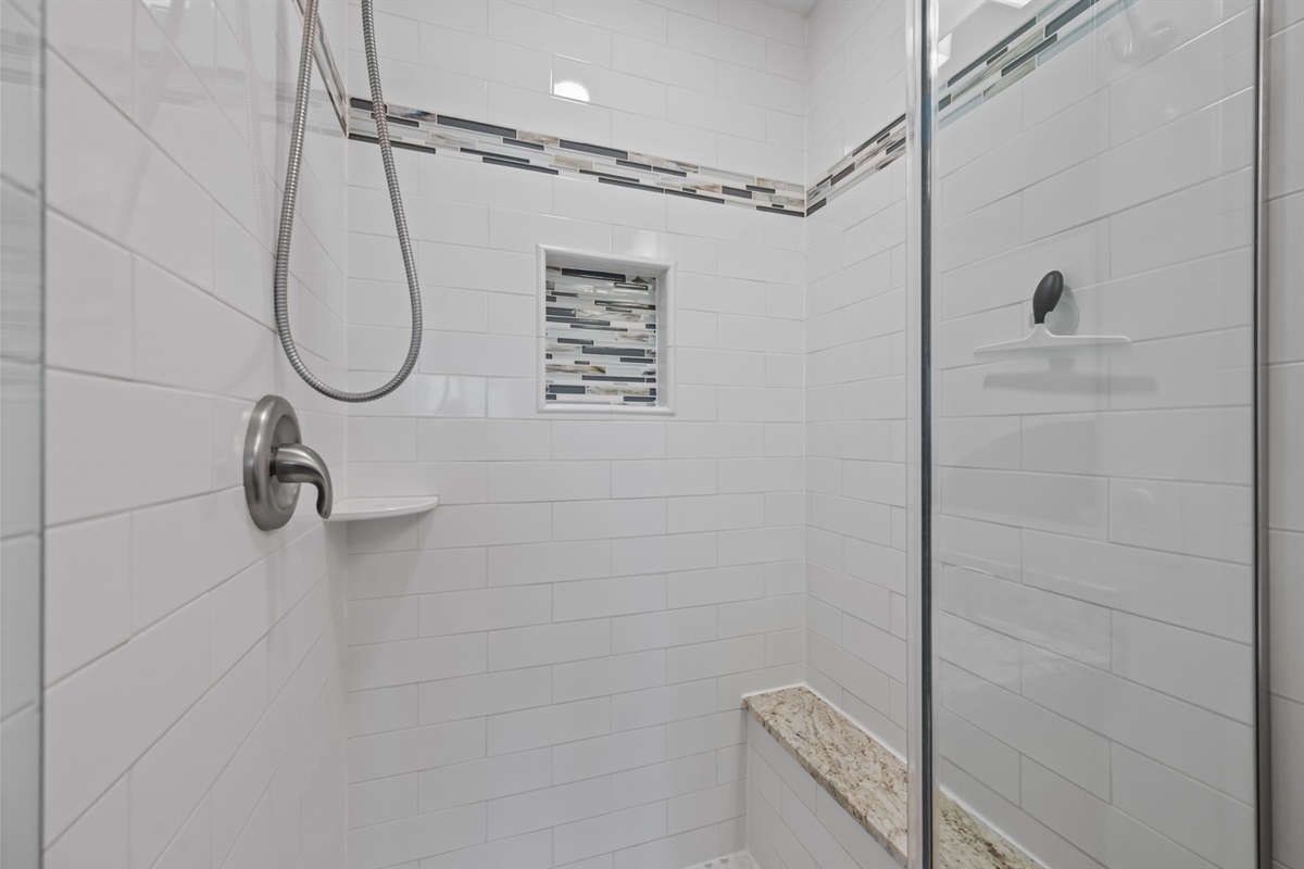 Walk-in shower with sleek tile and glass enclosure