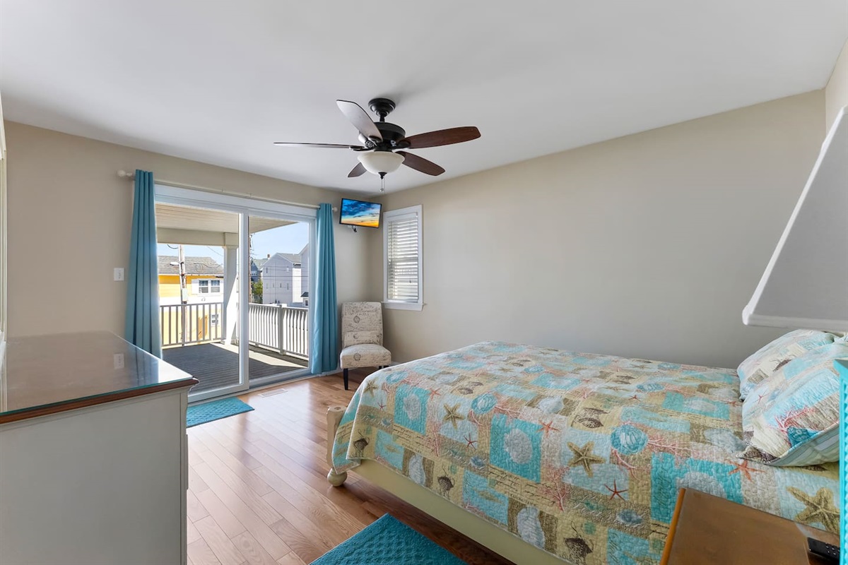 Bedroom offers a full size bed, dresser for storage, an attached bathroom and private access to a covered deck with beautiful views of the ocean. 