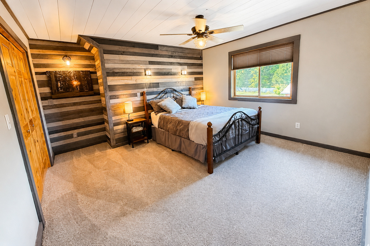 Comfortable guest bedroom with a rustic wood accent wall and plenty of space to recharge after a day on the trails.