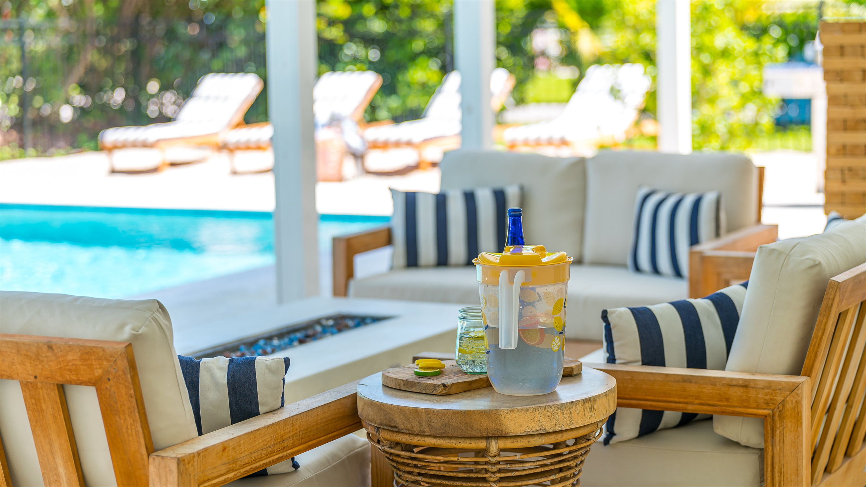 The pool deck is finished in shell white limestone, offering a beautiful natural backdrop.  By night, enjoy the tiki bar, TV, fire table, and the glow of the Jupiter Lighthouse Beacon 