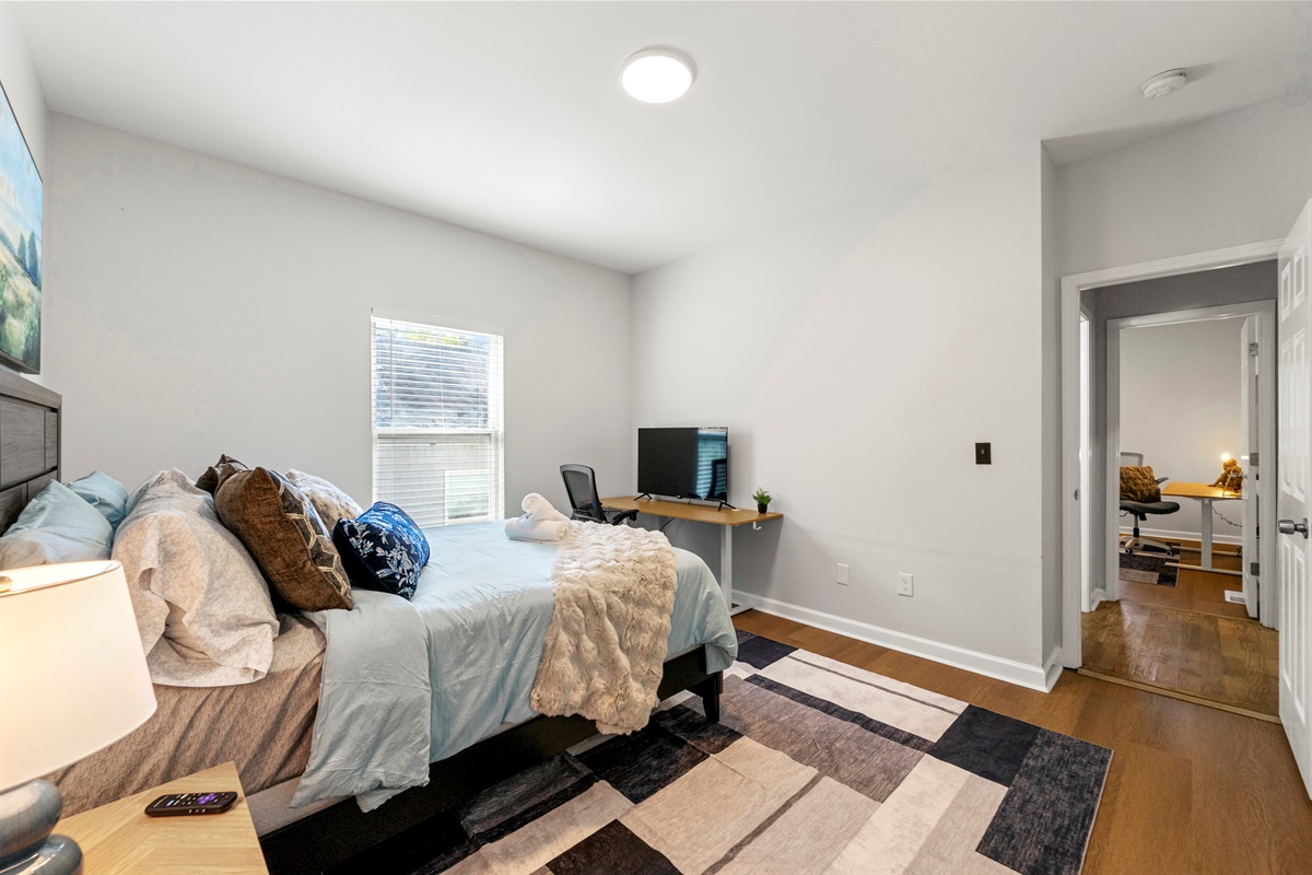 Charming bedroom with a comfy bed and desk—ideal for relaxation or remote work.