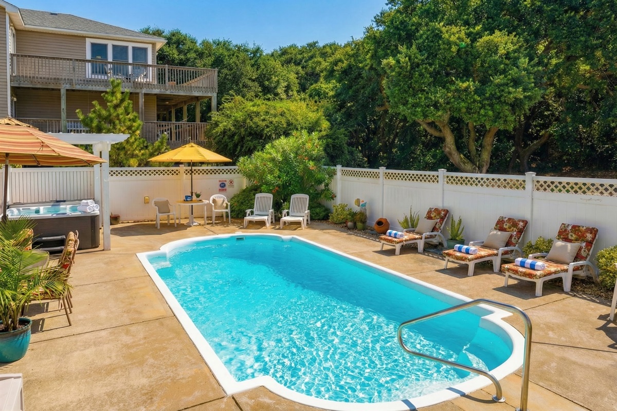 A view of the community amenities, featuring a large soundfront swimming pool and a long private pier with a gazebo for enjoying the water views.