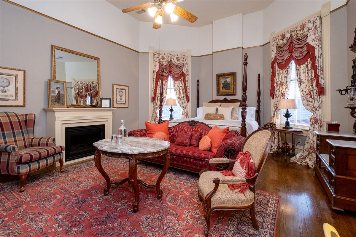 Spacious king suite featuring a four-poster bed, fireplace, and historic décor throughout.