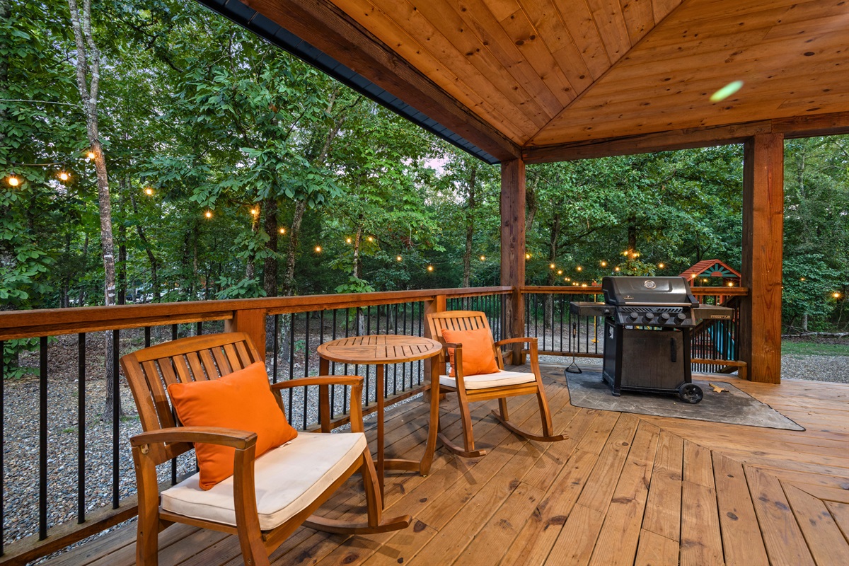 Covered deck with outdoor fireplace, dining, and lounge seating.