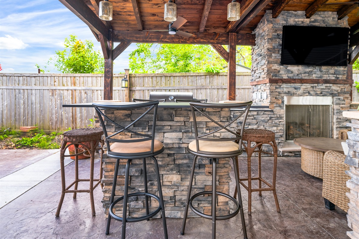 Gather under the stylish pavilion featuring a stone fireplace, TV, and grill for the ultimate outdoor hangout 🍔🔥📺