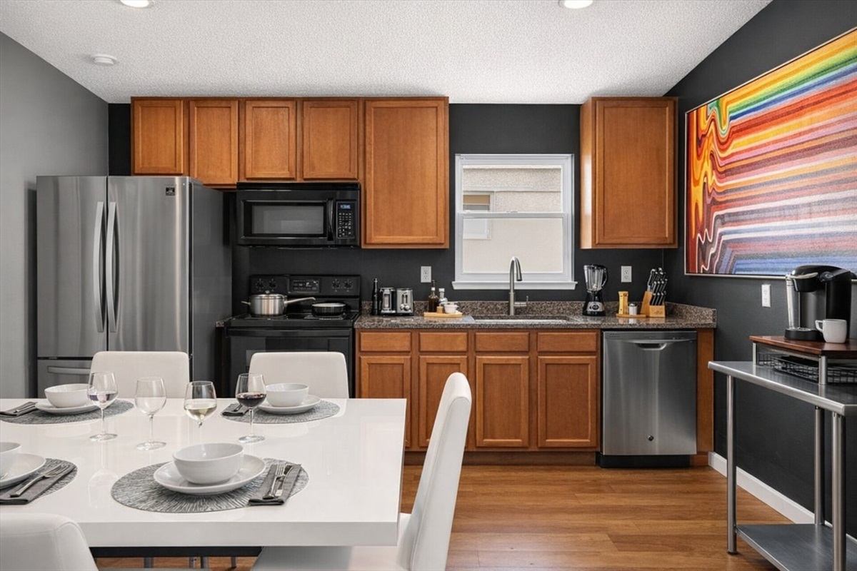 Modern fully equipped kitchen with stainless steel appliances a fully stocked coffee bar and a dining area for 10