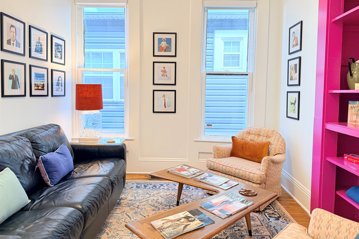 Ridiculously comfortable leather sofa layered with velvety-soft pillows and cozy blankets — designed for long afternoon reads and even longer naps.