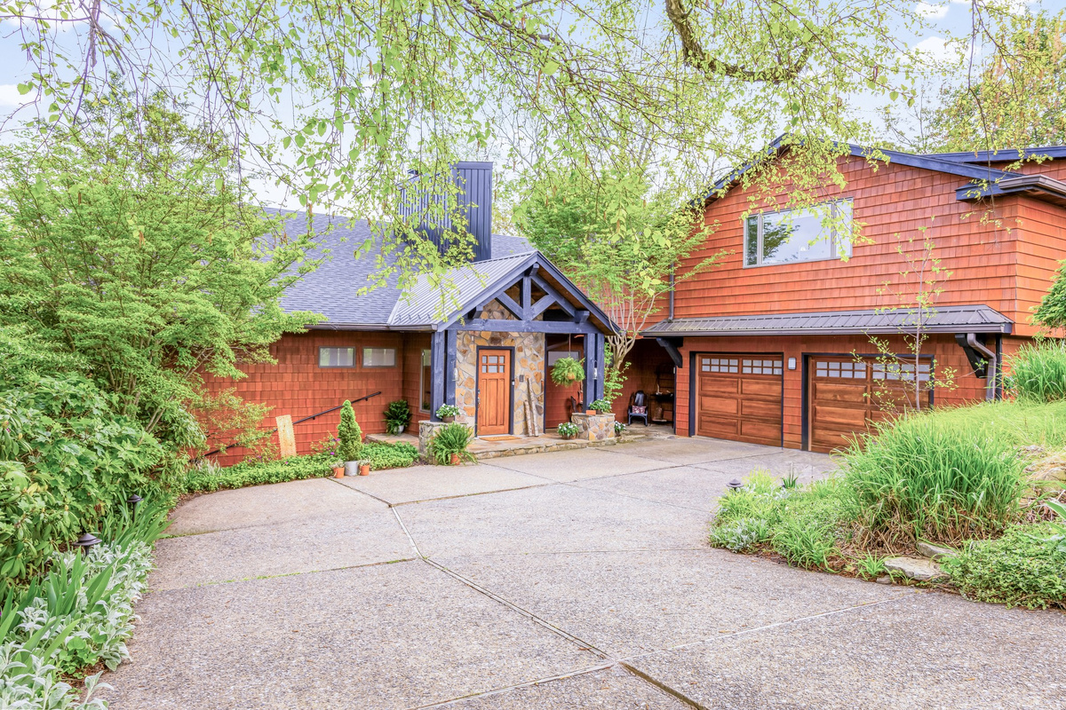 Private driveway parking for 3 cars off a quiet dead-end street. Enter from the stone porch and securely store bikes in the garage. Dense tree line creates privacy and a world-away experience.